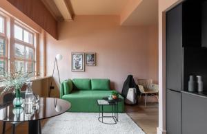ein Wohnzimmer mit einem grünen Sofa und einem Tisch in der Unterkunft Whitworth Locke in Manchester