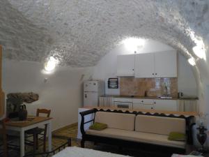 ein Wohnzimmer mit Sofa und eine Küche in der Unterkunft Irina Studios in Kýthira