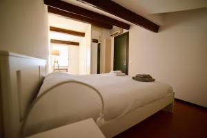 Una cama blanca en una habitación con ventana. en Casa Mosaico, en Vicenza