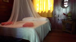 a bedroom with a bed with a mosquito net at Cabinas Nirvana Ecolodge in Cahuita