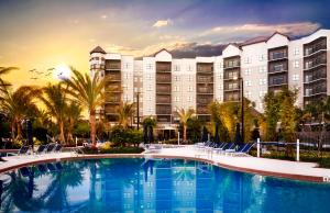 um grande hotel com uma grande piscina e cadeiras em The Grove Resort & Water Park Orlando em Orlando