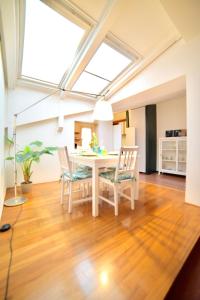 Un comedor con una mesa y sillas blancas. en Casa Mosaico, en Vicenza