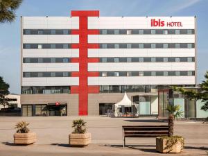 a building with a big red cross on it at Ibis Ripollet in Ripollet
