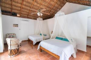 a bedroom with two beds and a ceiling fan at Collection O EcoVergel Hotel Boutique Spa in Tulum in Chemuyil +40 photos