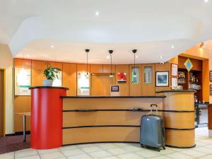 a lobby with a counter with a suitcase in it at ibis Wien City in Vienna