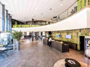 a person standing in the lobby of a building at Novotel Bern Expo in Bern