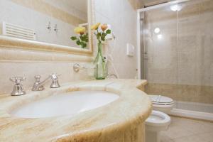 a bathroom with a marble sink with a vase of flowers at Hotel La Locanda in Volterra
