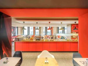 インスブルックにあるホテル イビス インスブルックのキッチン(赤いキャビネット、赤いカウンタートップ付)