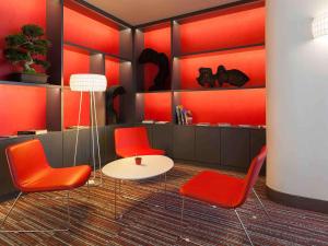 Zimmer mit roten Stühlen und einem weißen Tisch in der Unterkunft Hotel Mercure Lisboa in Lissabon