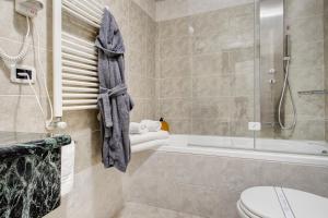 een badkamer met een douche, een toilet en een bad bij Hotel La Locanda in Volterra