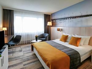 a hotel room with a large bed and a large window at Mercure Gdynia Centrum in Gdynia