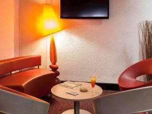 una camera d'albergo con tavolo, sedie e lampada di ibis Auch ad Auch