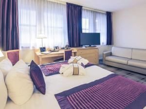 a hotel room with a large bed and a couch at Mercure Tours Centre Gare et Congrès in Tours