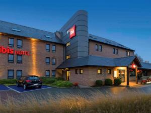 a hotel with a car parked in a parking lot at ibis Brussels Waterloo in Waterloo