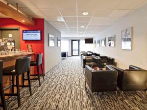 a living room filled with furniture and a bar at ibis Brussels Waterloo in Waterloo
