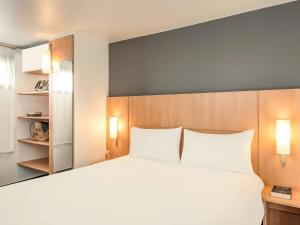 a bedroom with a large white bed with two pillows at ibis Paris Bastille Faubourg St Antoine in Paris