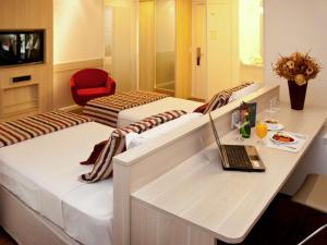 a hotel room with two beds and a laptop on a desk at Mercure Brasilia Lider in Brasilia