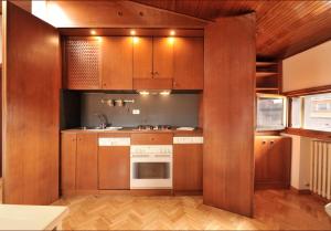 een keuken met houten kasten en een wastafel bij UR-NEST San Martino in Bologna
