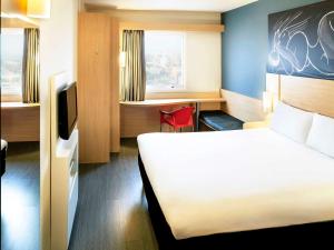ein Hotelzimmer mit einem Bett und einem Schreibtisch in der Unterkunft ibis Macae in Macaé
