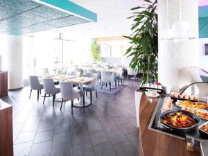 un comedor con mesas y sillas y un buffet en Novotel Suites Hannover en Hannover