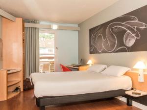 een hotelkamer met een groot bed en een raam bij ibis La Bresse Gérardmer in La Bresse