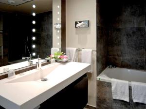 a bathroom with a sink and a bath tub at Mercure Abbeville Centre – Porte de La Baie de Somme in Abbeville