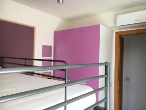 Cette chambre comprend 2 lits superposés et une armoire violette. dans l'établissement Le Vele Apartment, à Vasto