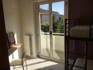 - une chambre avec une porte coulissante en verre donnant sur un balcon dans l'établissement Le Vele Apartment, à Vasto