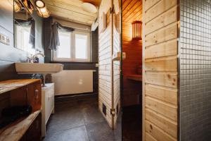 een badkamer met houten wanden, een wastafel en een spiegel bij Haus Anna Elbe, Bauernhaus-Ferienwohnungen an der Elbe in Hamburg