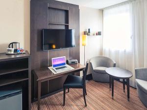 a hotel room with a desk with a laptop on it at Hotel Mercure Rennes Cesson in Cesson-Sévigné