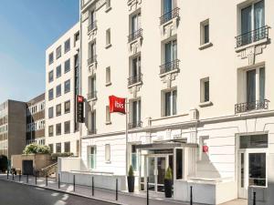 a white building with a red hotel sign on it at ibis Paris Boulogne Billancourt in Boulogne-Billancourt