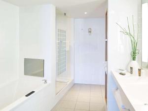 a white bathroom with a shower and a sink at Novotel Liverpool Centre in Liverpool