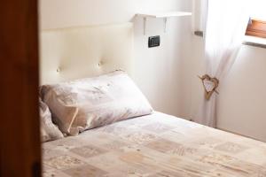 - une chambre avec un lit doté d'un oreiller et d'une fenêtre dans l'établissement StudiÒ Aubert, à Aoste