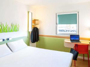 1 dormitorio con 1 cama y escritorio con ordenador portátil en ibis budget Leicester, en Leicester