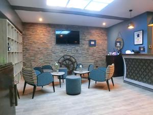 a restaurant with tables and chairs and a tv on a brick wall at Hotel Sur Le Quai in Port-Vendres