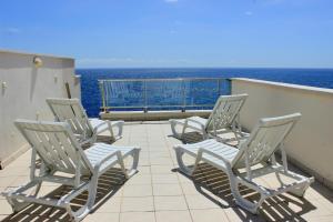 un grupo de sillas sentadas en un balcón con vistas al océano en Ocean View Apartment, en Porís de Abona