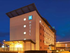 ニューポートにあるibis budget Newportの夜間の看板が貼られたホテルの建物