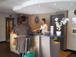 two women are standing at a counter in a salon at ibis Styles Angers Centre Gare in Angers