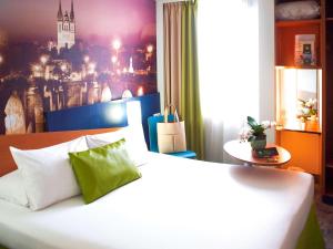 アンジェにあるibis Styles Angers Centre Gareの白いベッド1台付きのベッドルーム1室(壁に絵画付)