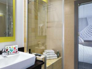 ein Badezimmer mit einem weißen Waschbecken und einer Dusche in der Unterkunft Ibis Styles Nice Centre Port in Nizza