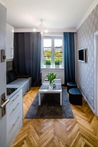 - un salon avec un canapé et une table dans l'établissement Cracovia Apartments, à Cracovie