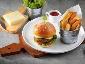 a plate with a hamburger and french fries on a table at Ibis Phuket Kata in Kata Beach