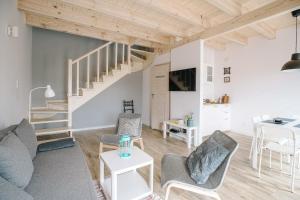 a living room with a couch and chairs and a staircase at Domki Kalinowa14 Kopalino in Kopalino