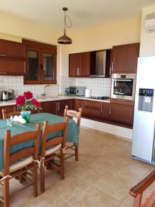 a kitchen with a table and chairs and a refrigerator at Villa Ikarus in Triopetra