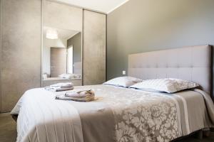 ein Schlafzimmer mit einem großen Bett und einem großen Spiegel in der Unterkunft Villa du Macchione BASTIA in Bastia