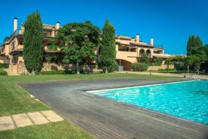 a swimming pool in front of a large house at Costabravaforrent Residencial Albons in Albóns