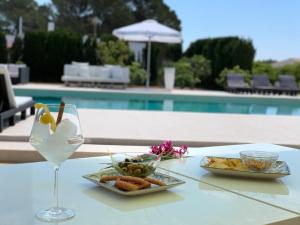 - une table avec une assiette de nourriture et un verre de vin dans l'établissement MAR I MONTANYA Formentera 2, à Sant Francesc Xavier