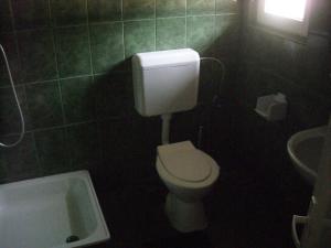 a bathroom with a white toilet and a sink at Pensiunea Montan Busteni in Buşteni