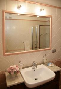 a bathroom with a sink and a large mirror at Agriturismo Cascina Lavaroni in Buttrio