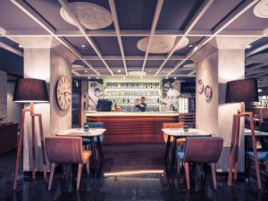 a restaurant with tables and chairs and a bar at Mercure Jakarta Sabang in Jakarta